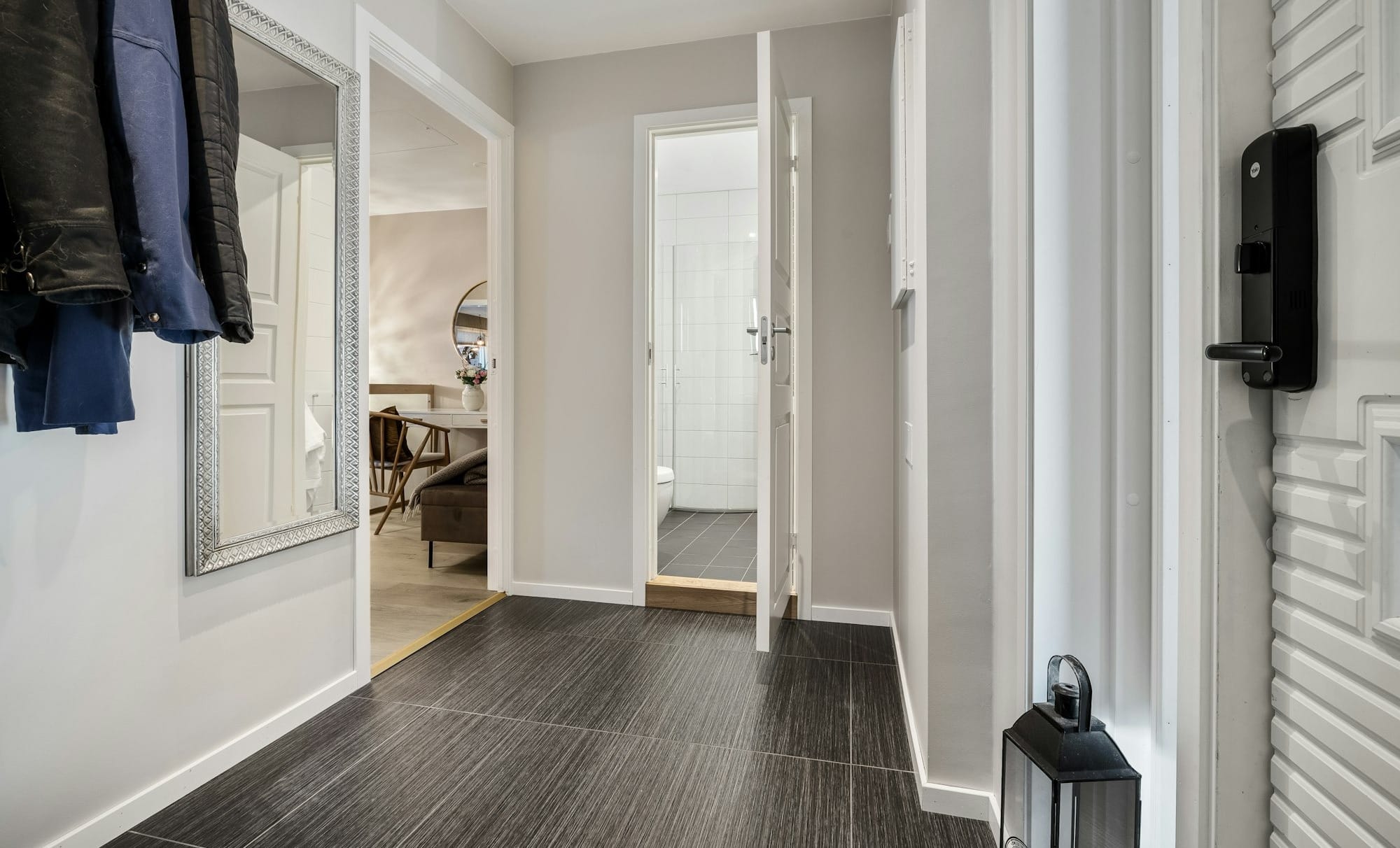 A hallway with a black and white floor and white walls