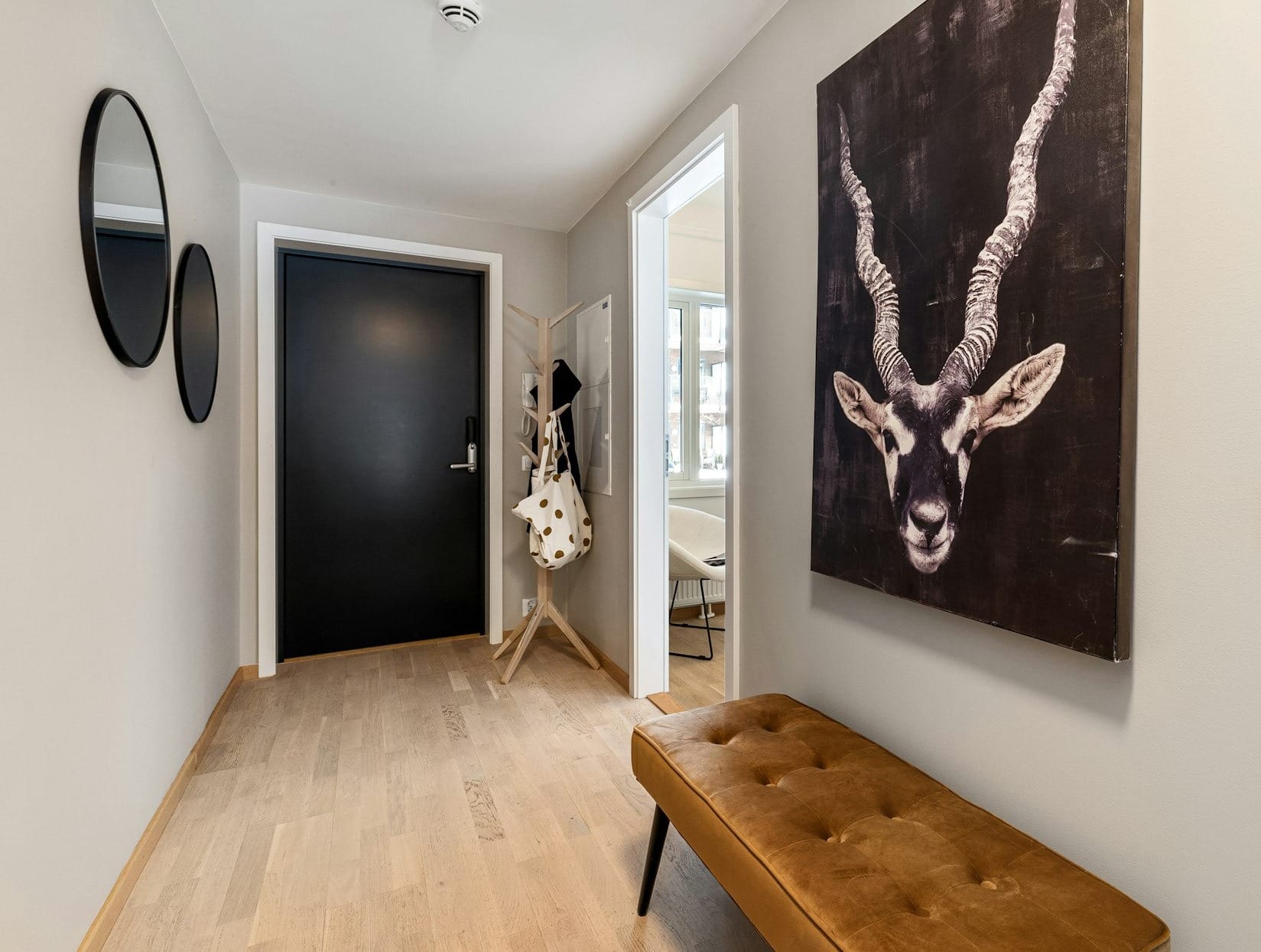 A hallway with a bench and paintings on the wall